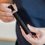 Man trekt glazen spray flesje uit RDT spray houder van Barista-Essentials